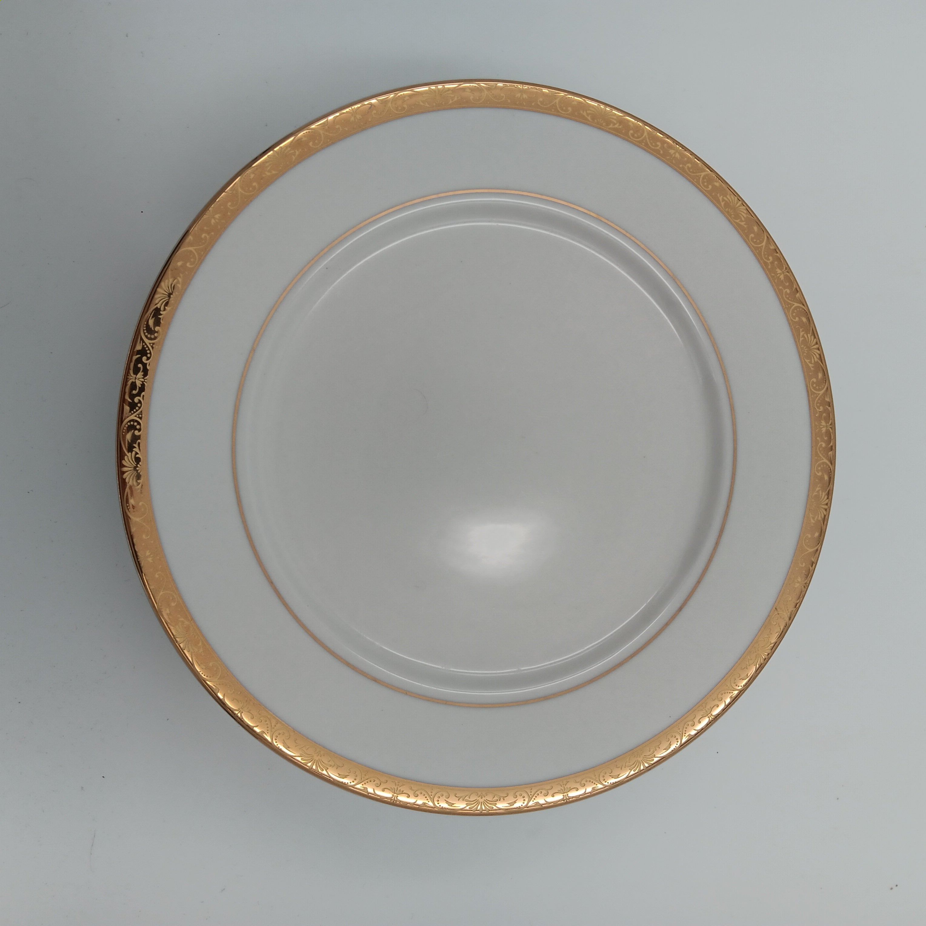 Elegant white porcelain dinner plate with gold trim from luxury china set