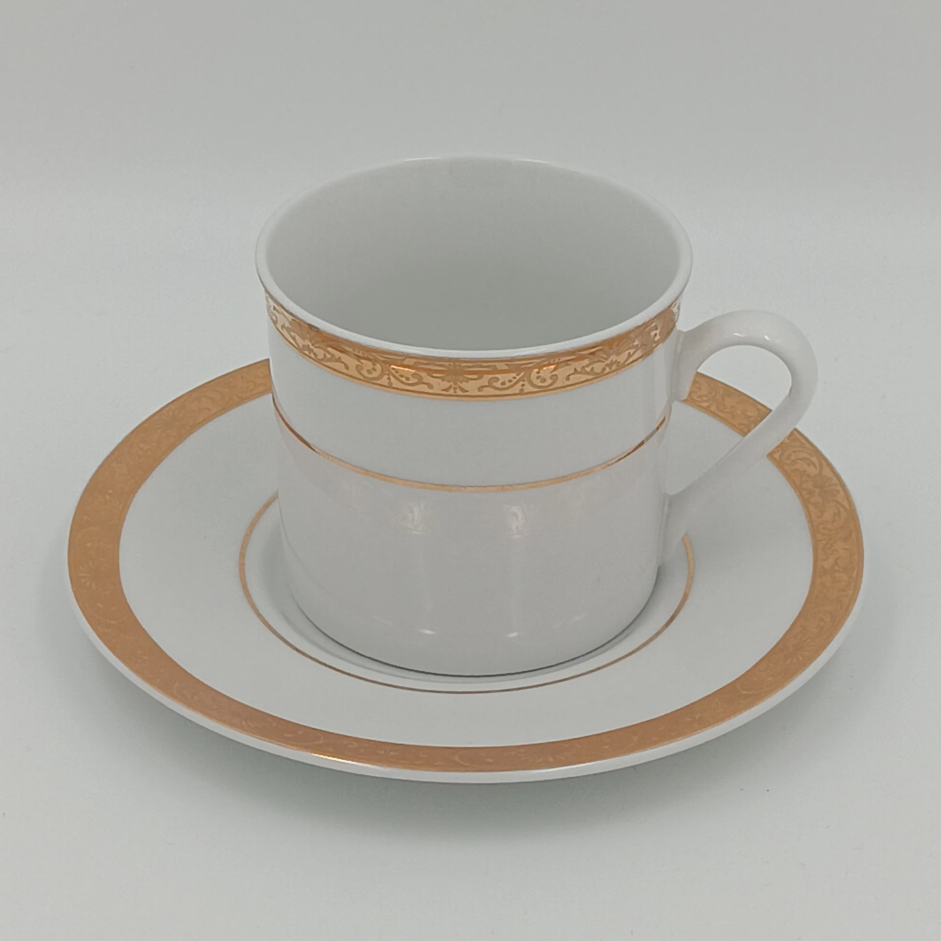 White porcelain teacup and saucer with gold detailing, part of 30-piece china set