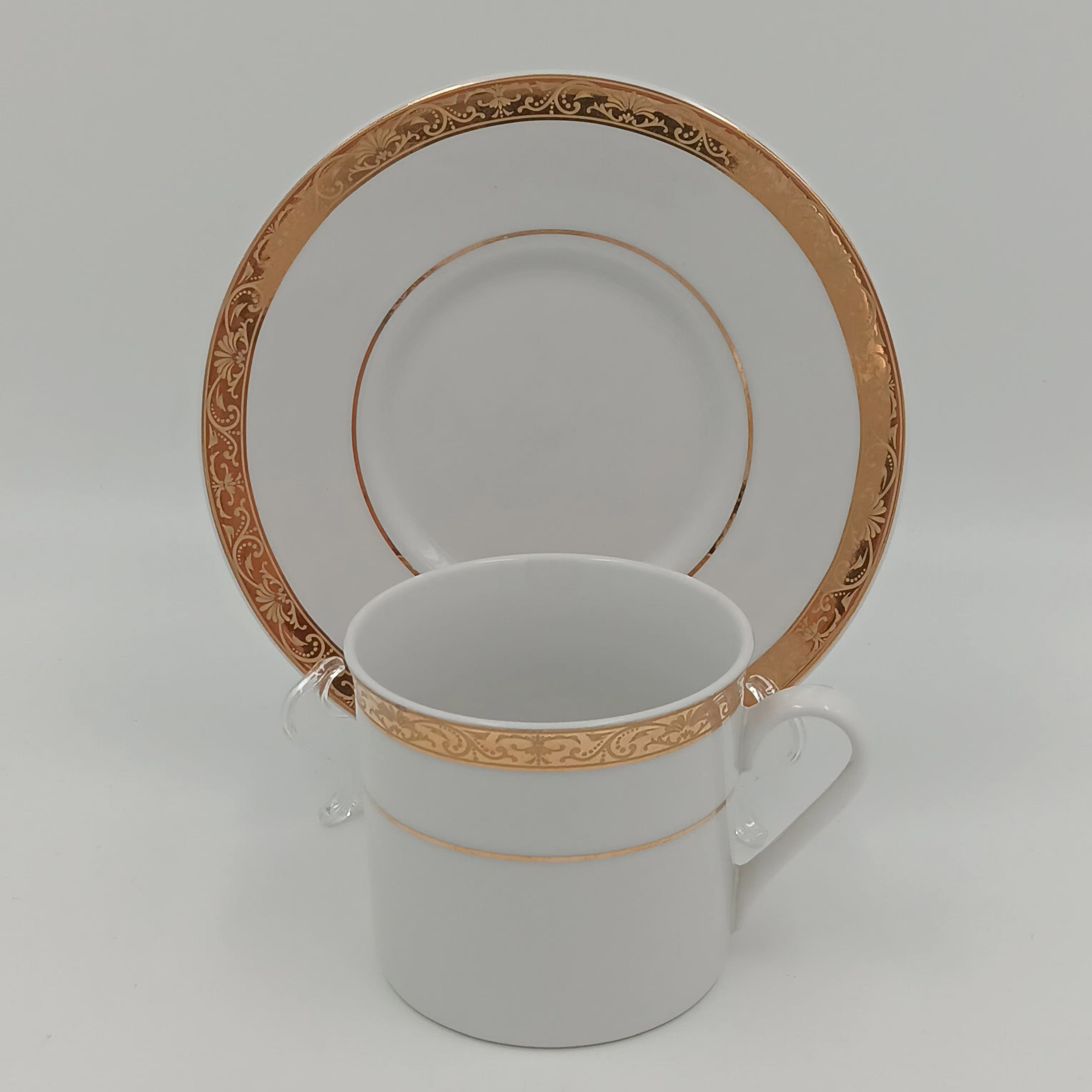 White porcelain teacup and saucer with gold detailing, part of 30-piece china set