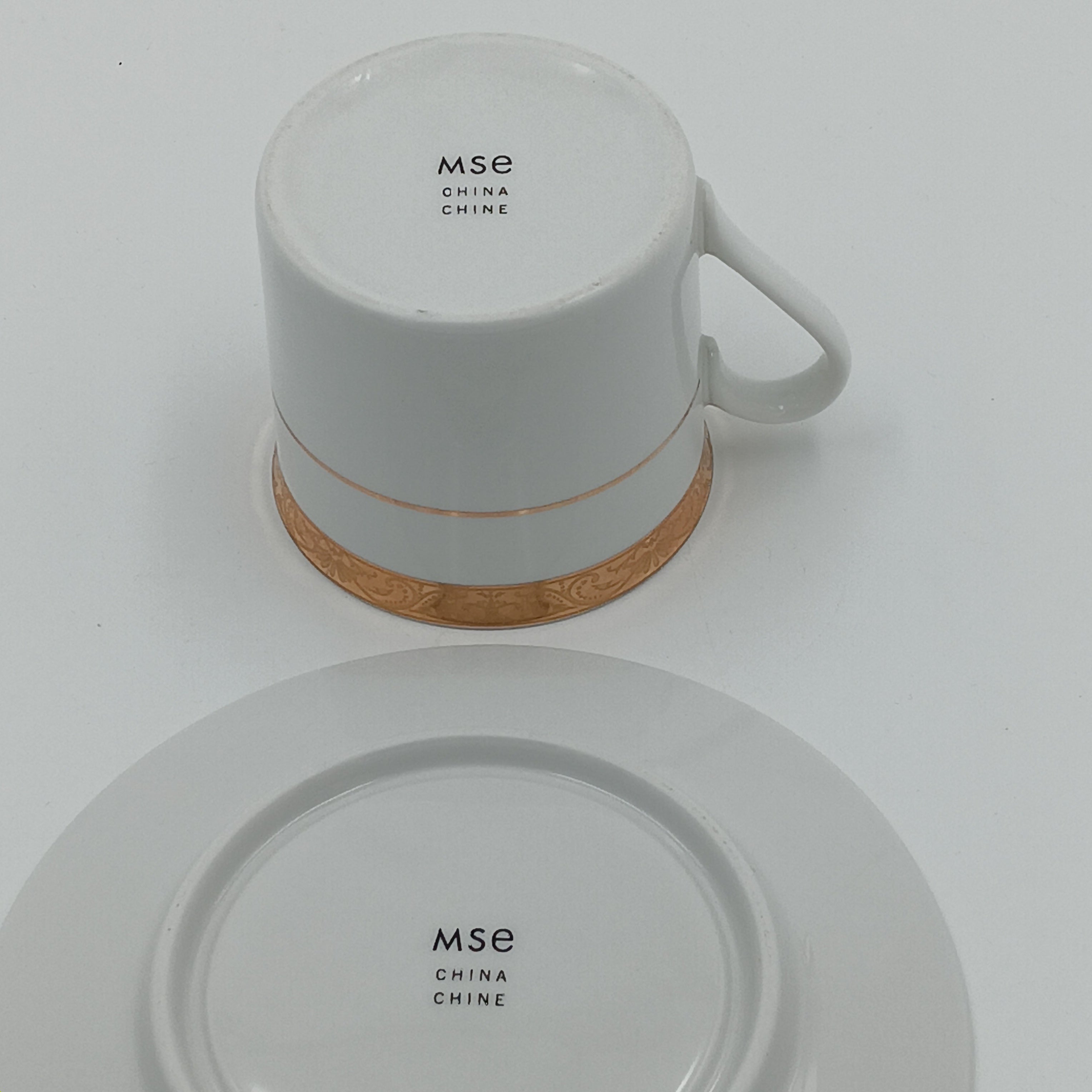 White porcelain teacup and saucer with gold detailing, part of 30-piece china set