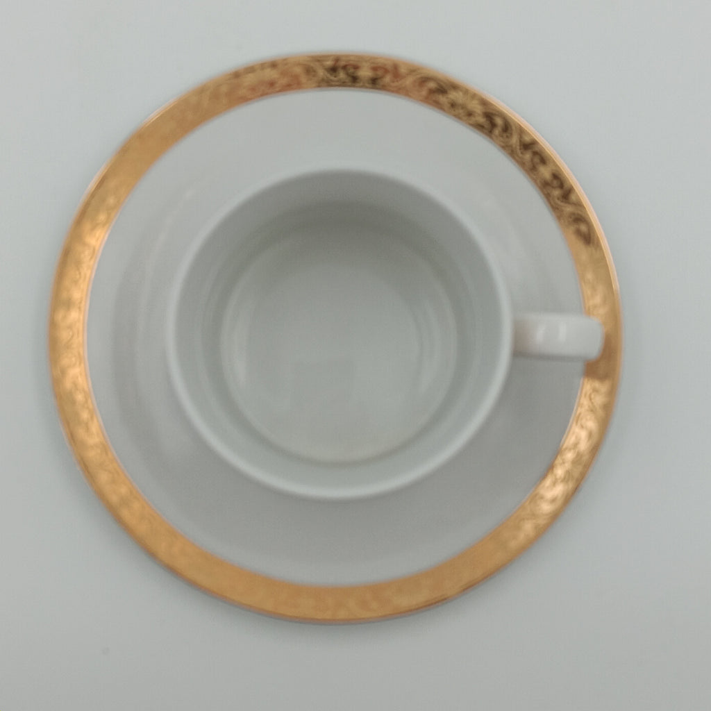 White porcelain teacup and saucer with gold detailing, part of 30-piece china set