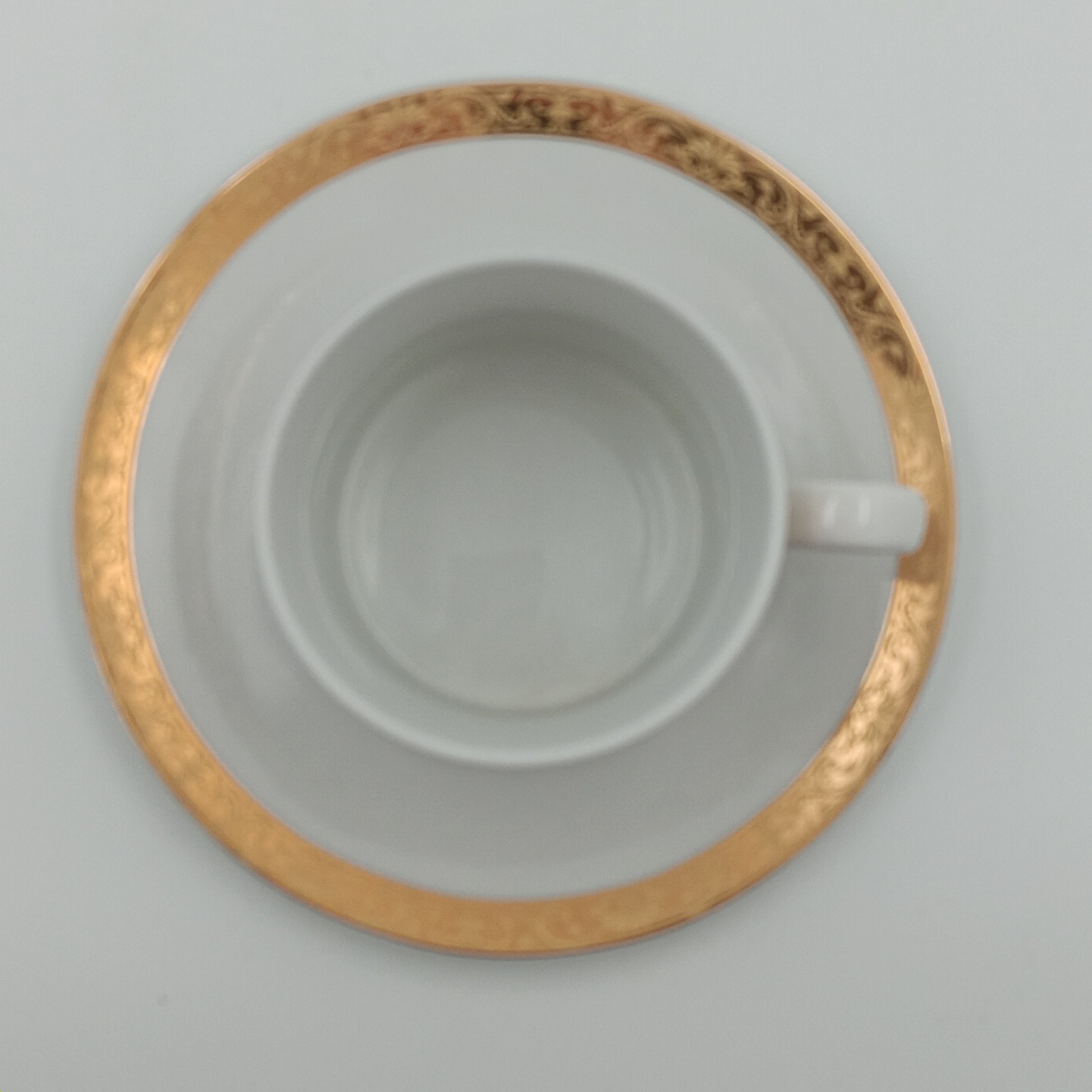 White porcelain teacup and saucer with gold detailing, part of 30-piece china set