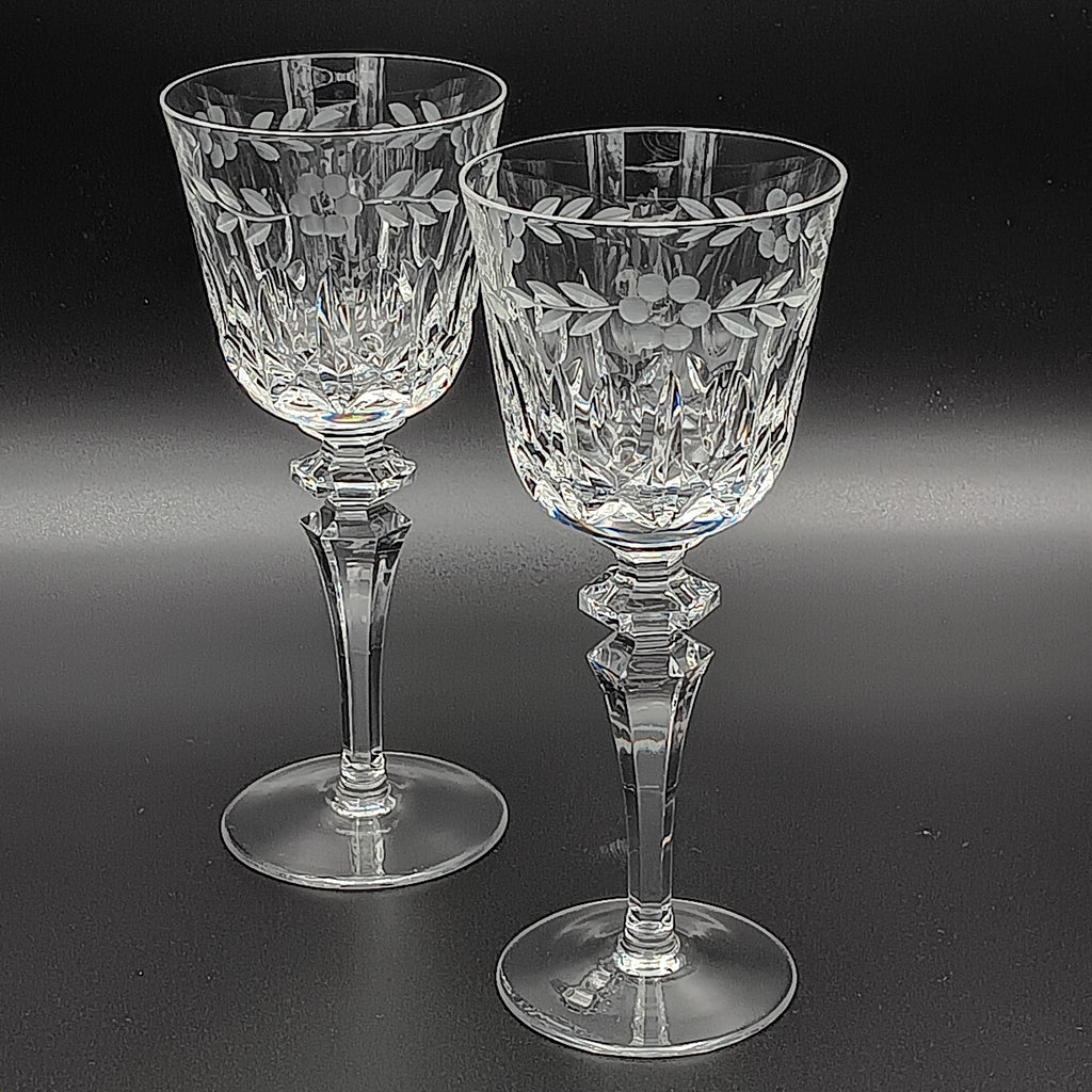 Two crystal glasses with floral etching on a black background