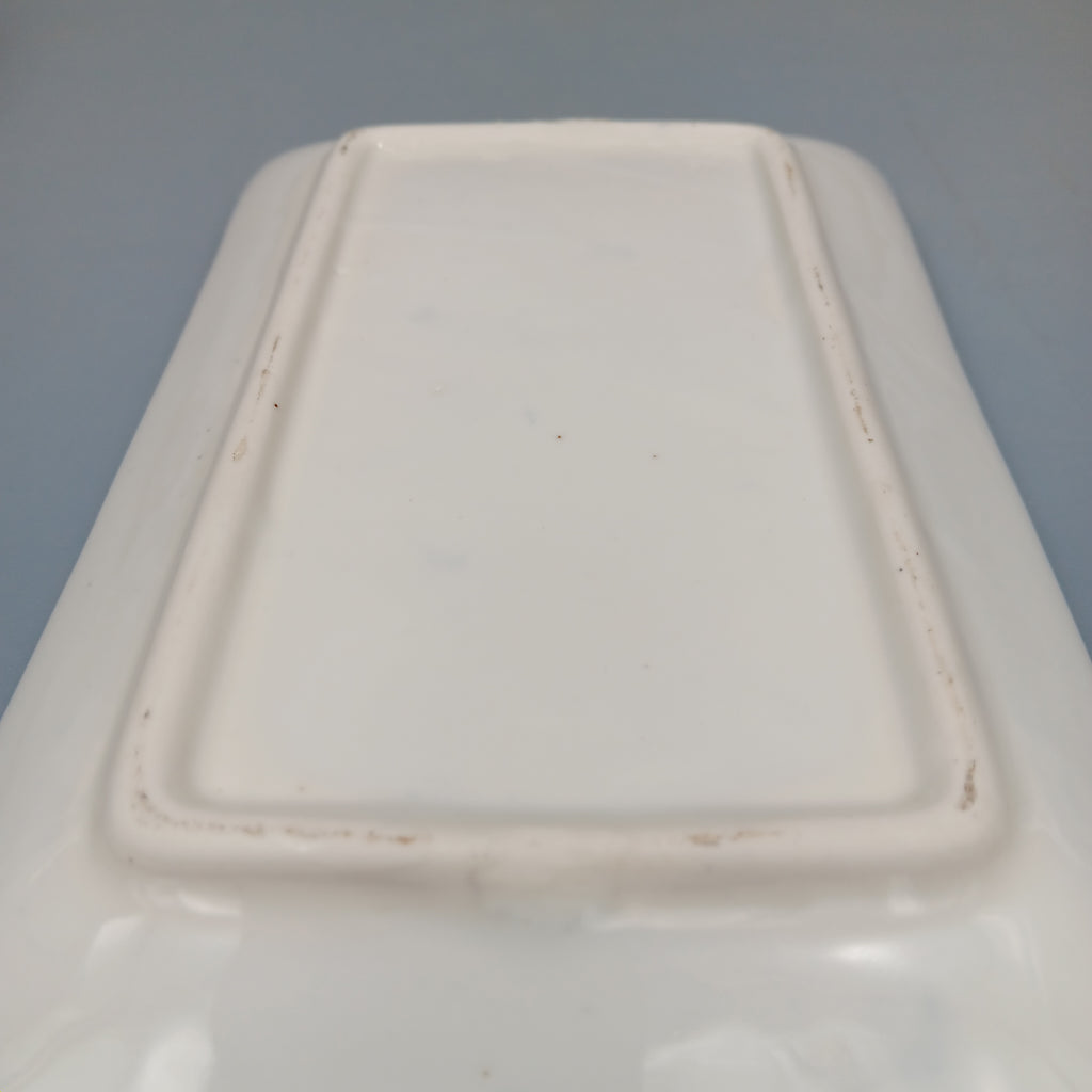 Underside of a rectangular white porcelain plate showing raised foot rim and subtle kiln marks, indicative of late Qing to early Republic period craftsmanship.