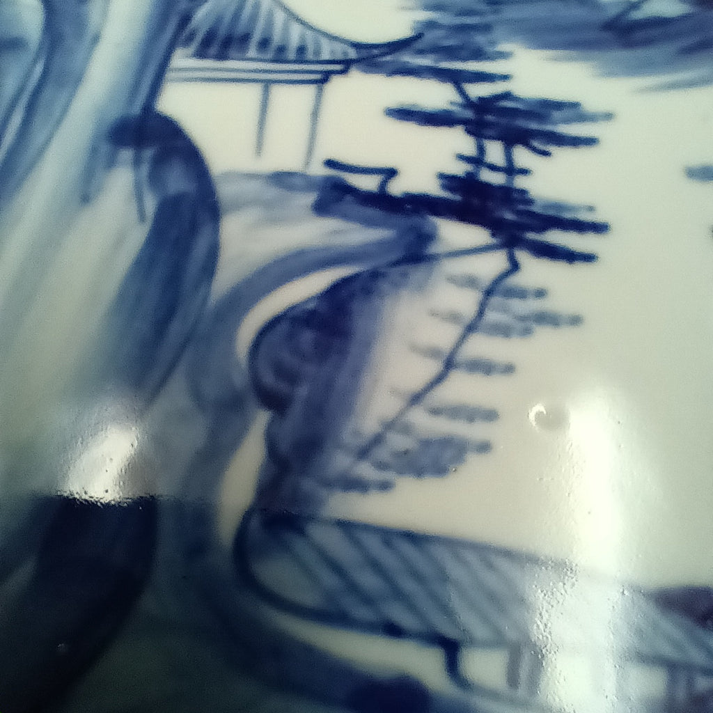 Antique Chinese blue and white porcelain dish with hand-painted landscape scene featuring mountains, trees, and a pavilion in cobalt blue on a rectangular ceramic dish.