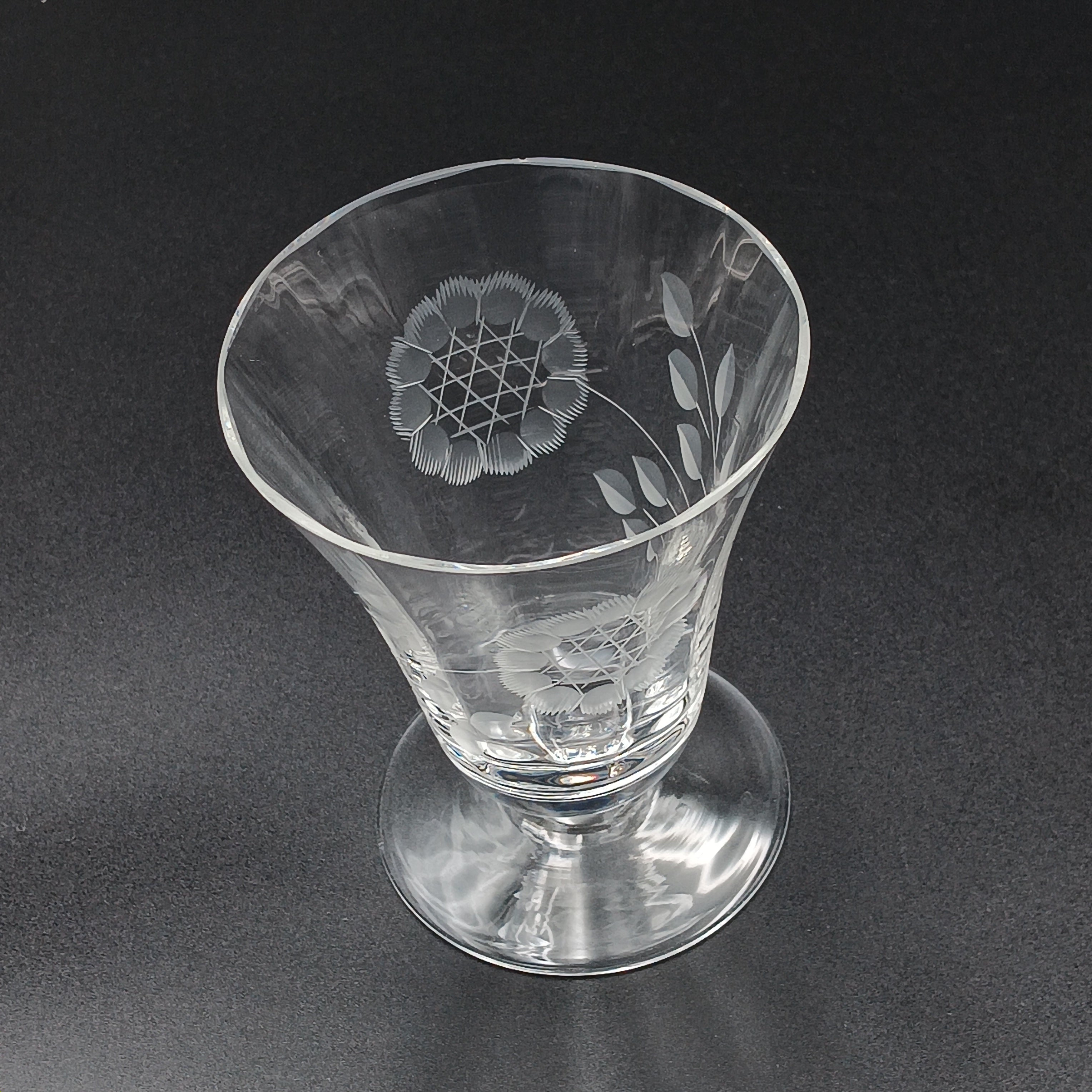 Clear glass W.J. Hughes Cornflower footed tumbler with etched floral design, wide rim tapering to a flared circular base