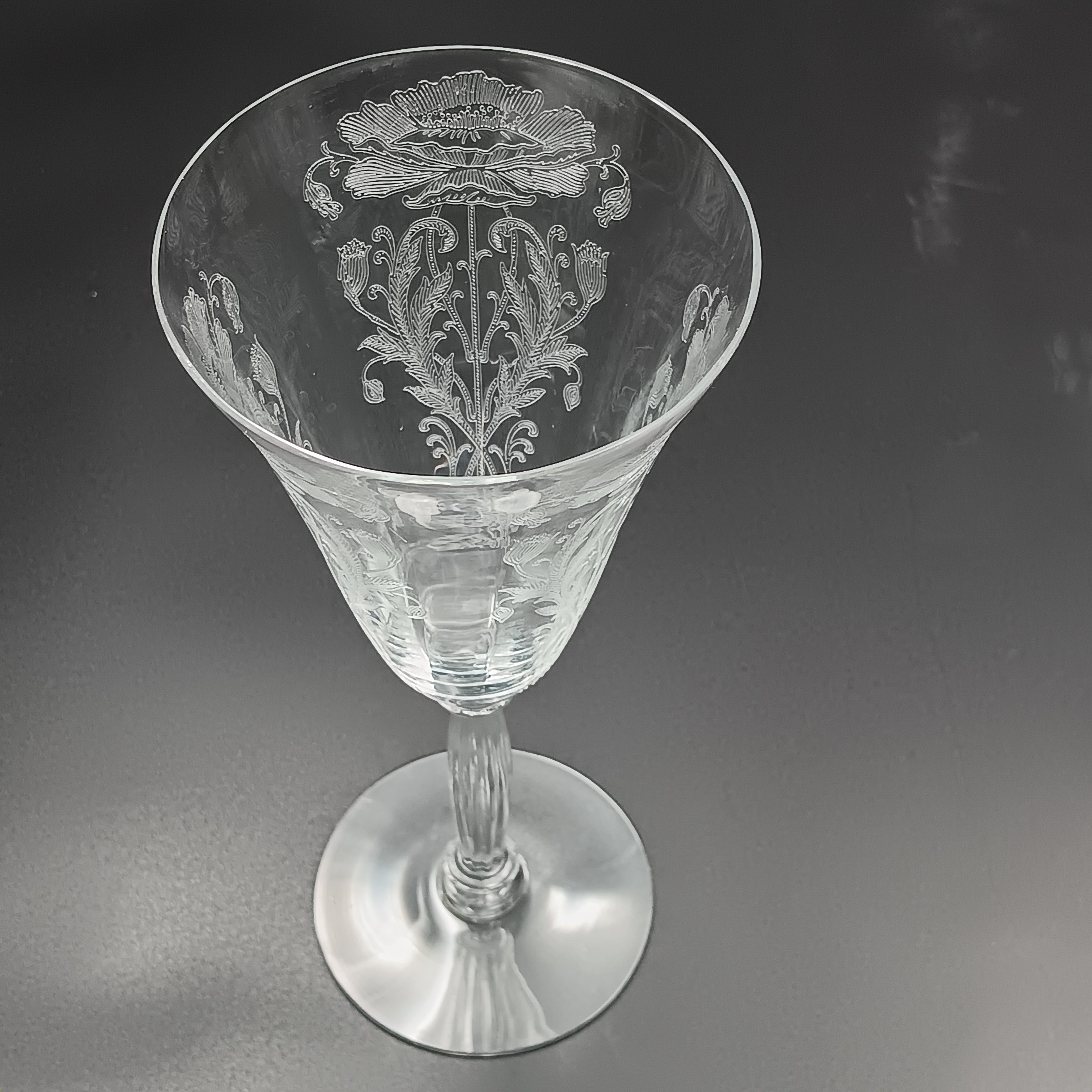 Vintage Tiffin-Franciscan 'Flanders Clear' 8¼ inch water goblet featuring intricate floral etching on the bowl, a ribbed stem, and a flat circular base.