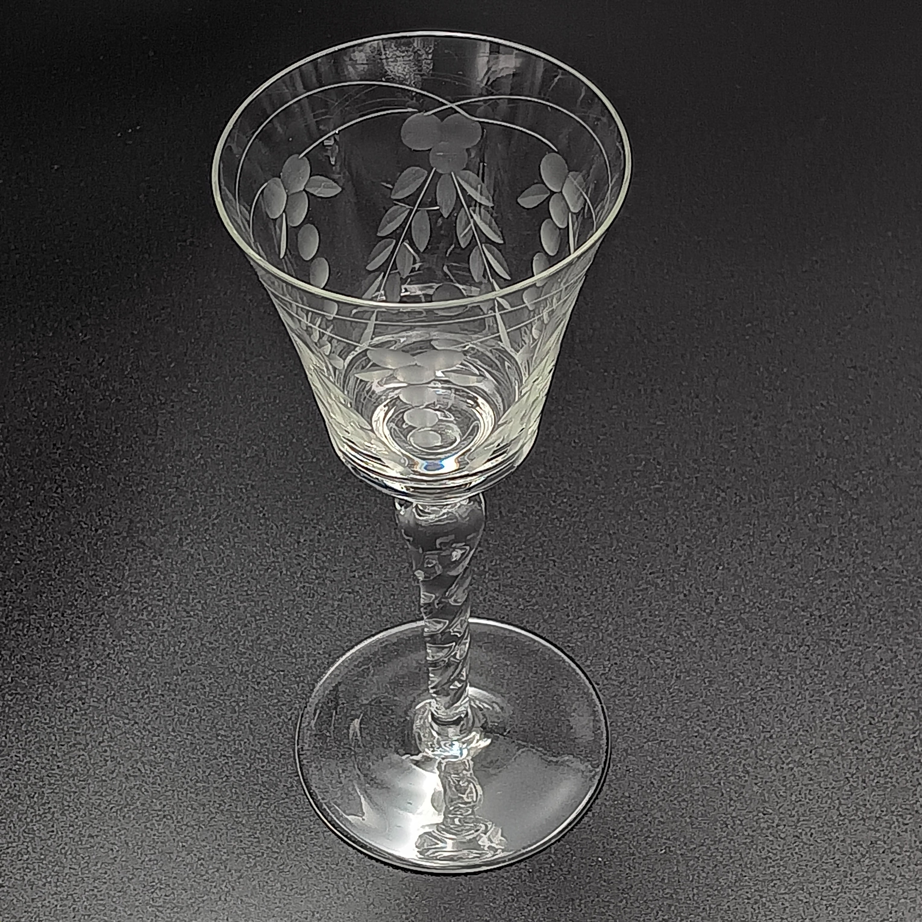 A 6-inch cut crystal wine glass featuring etched leaf and berry patterns on the bowl, a twisted textured stem, and a flat base.