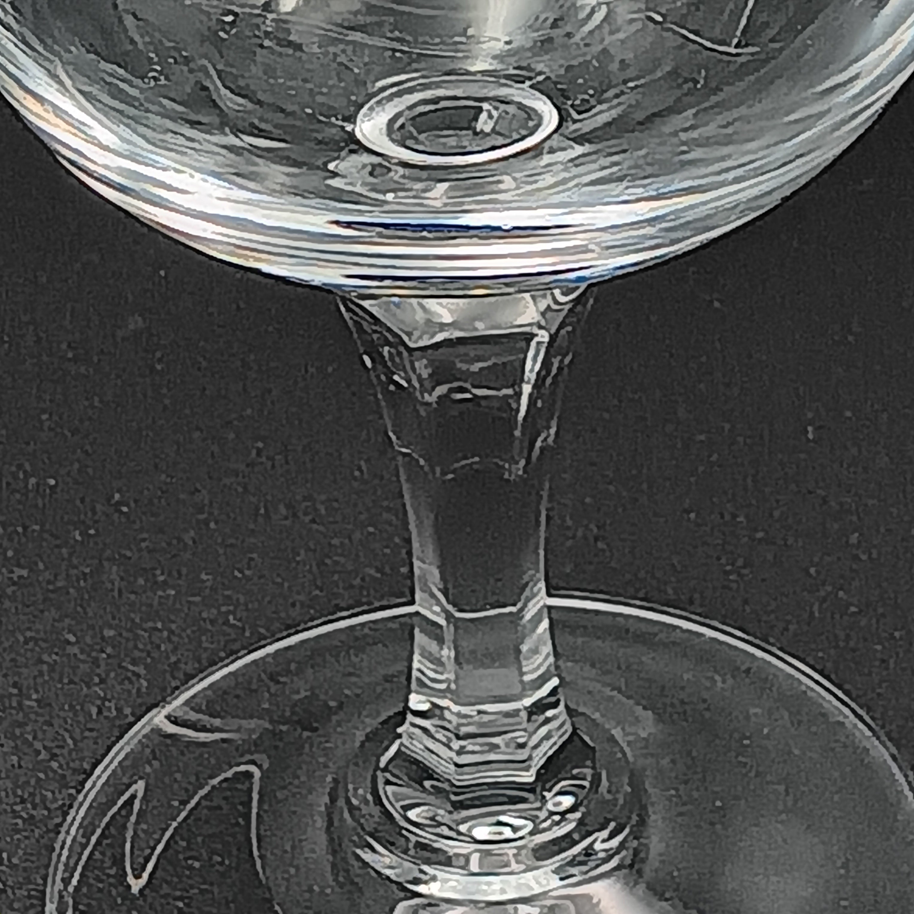 Clear crystal wine glass with etched floral and vine patterns.