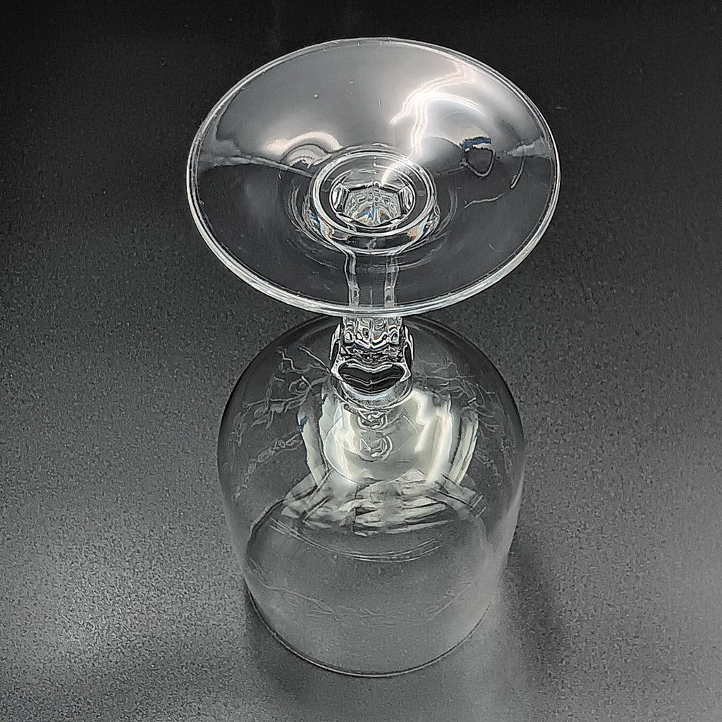 Clear crystal wine glass with etched floral and vine patterns.