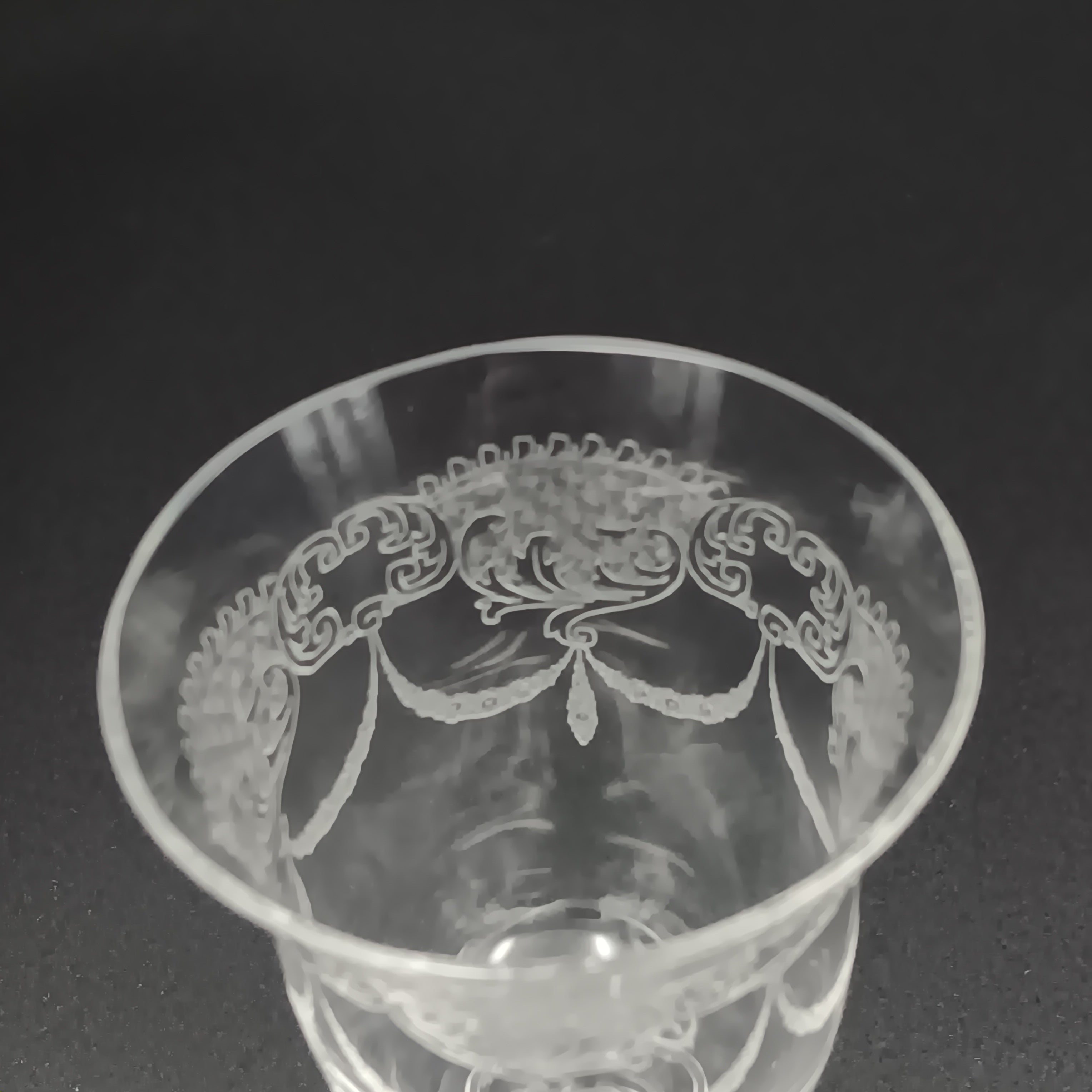 Clear 4½-inch etched crystal wine glass with ornate floral and crown-like patterns on the bowl, faceted stem, and wide flat base