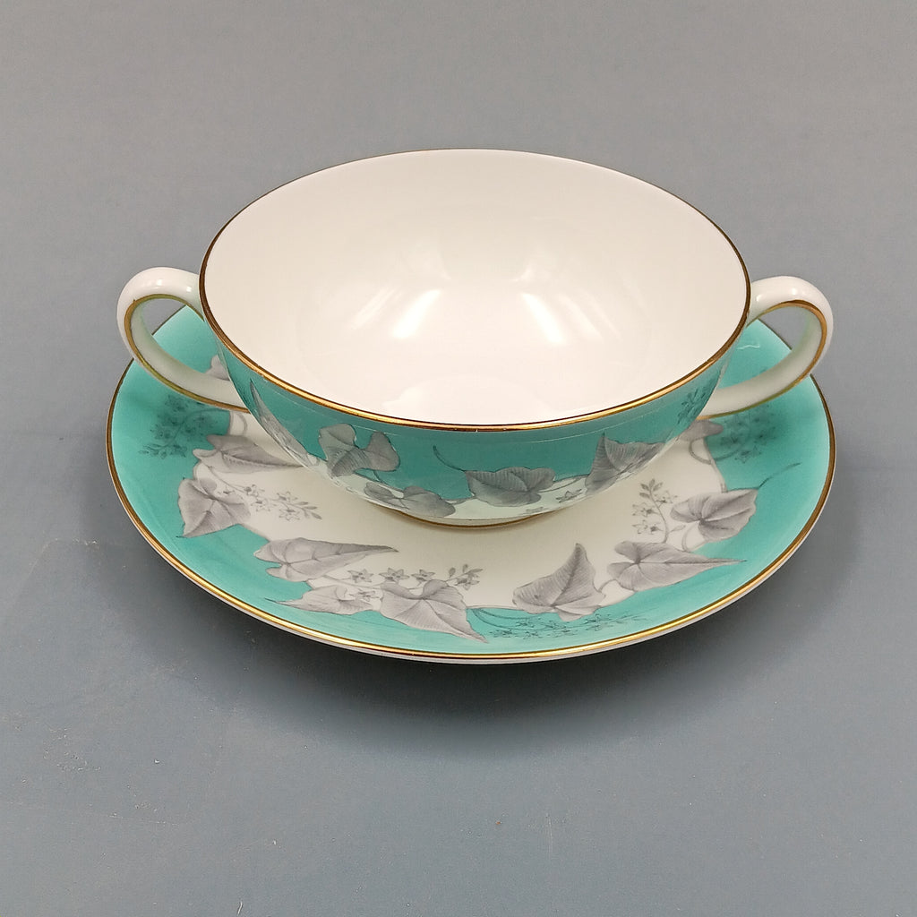 Wedgwood 'Buxton' double-handled soup bowl and saucer set featuring a turquoise background with gray and white floral design, accented by gold trim on edges; elegant English porcelain tableware ideal for collectors.
