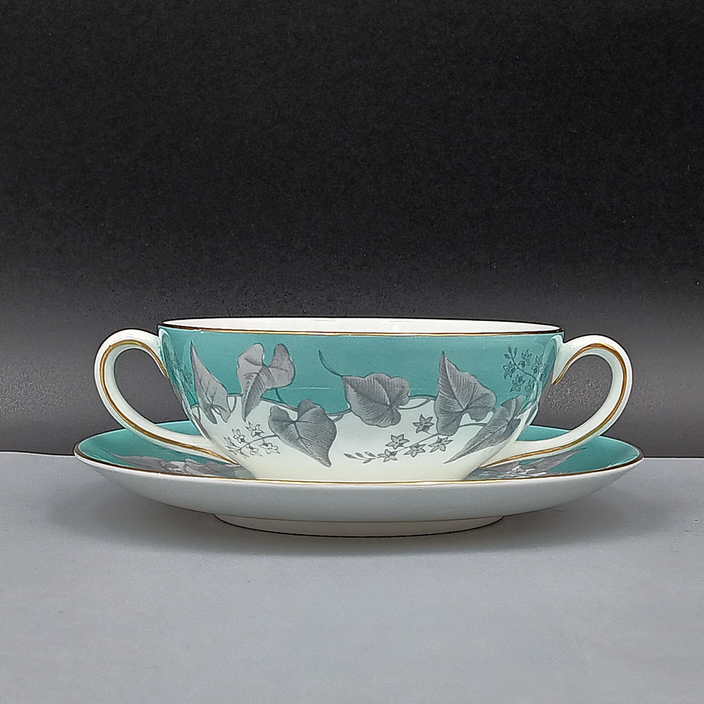 Wedgwood 'Buxton' double-handled soup bowl and saucer set featuring a turquoise background with gray and white floral design, accented by gold trim on edges; elegant English porcelain tableware ideal for collectors.