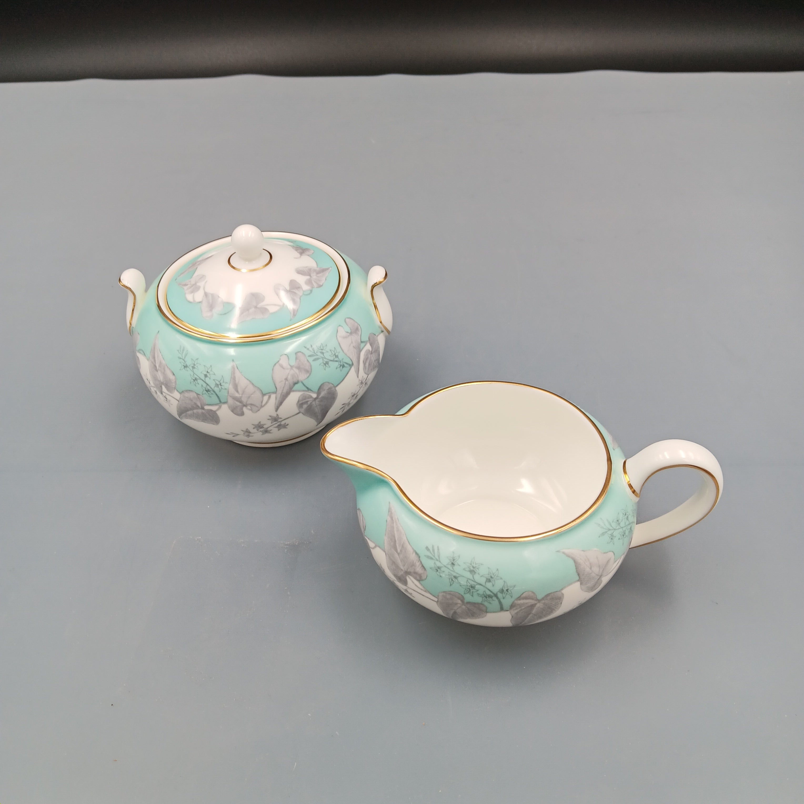 Wedgwood Buxton Turquoise cream and sugar set with gold trim and floral design.