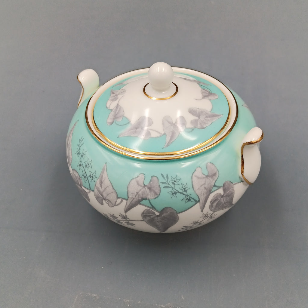 Vintage Wedgwood ‘Buxton Turquoise’ lidded sugar dish with white porcelain body, turquoise band, gray floral motif, and gold-trimmed handles and lid.