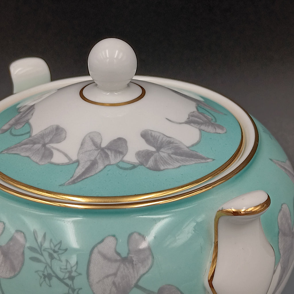 Vintage Wedgwood ‘Buxton Turquoise’ lidded sugar dish with white porcelain body, turquoise band, gray floral motif, and gold-trimmed handles and lid.