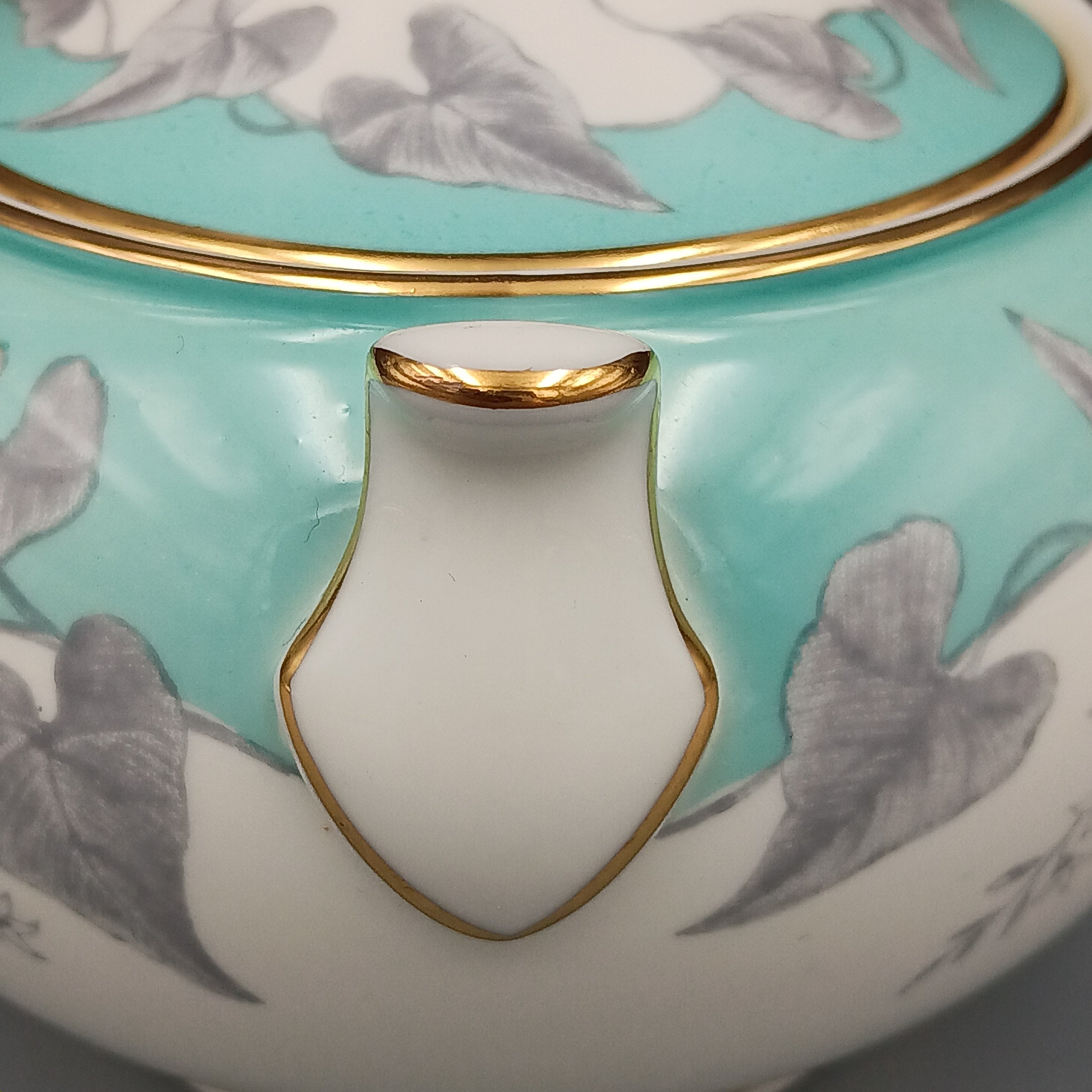 Vintage Wedgwood ‘Buxton Turquoise’ lidded sugar dish with white porcelain body, turquoise band, gray floral motif, and gold-trimmed handles and lid.
