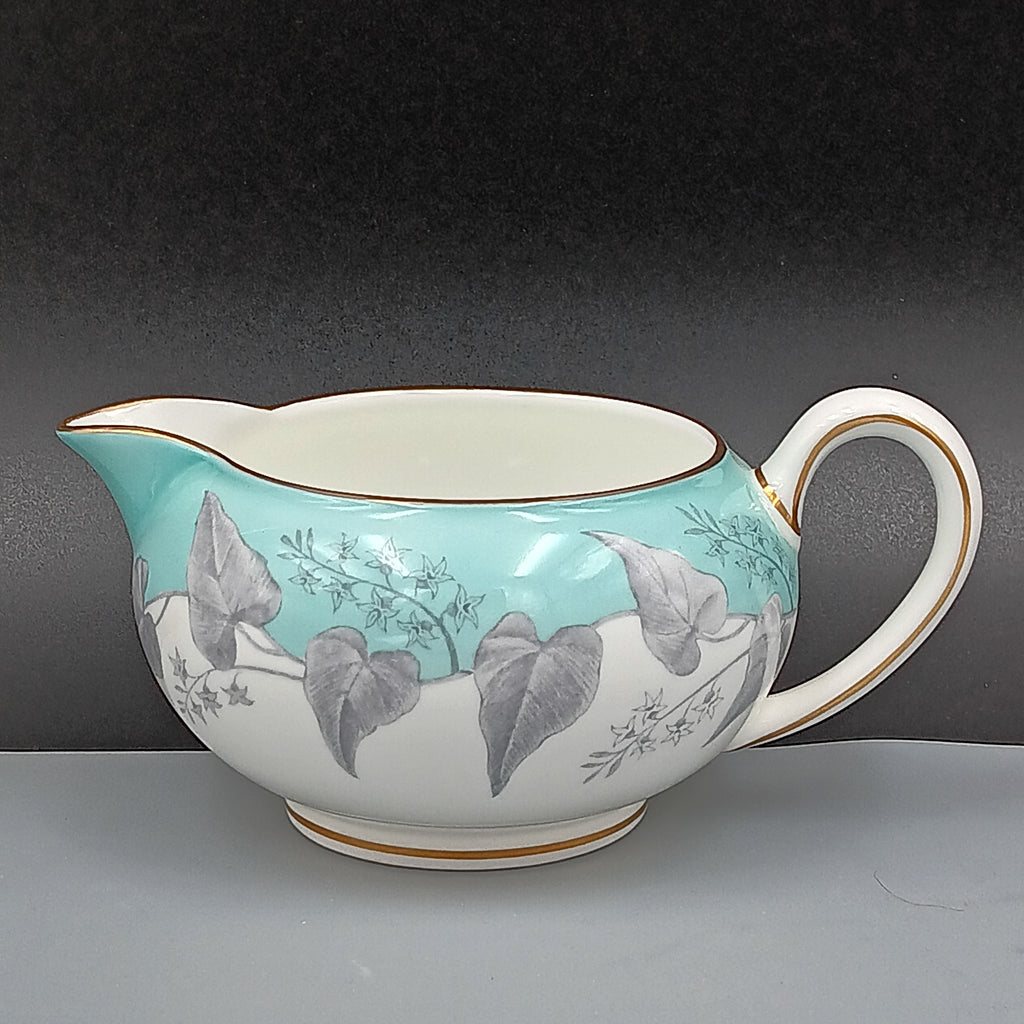 Creamer with floral design on a gray background.