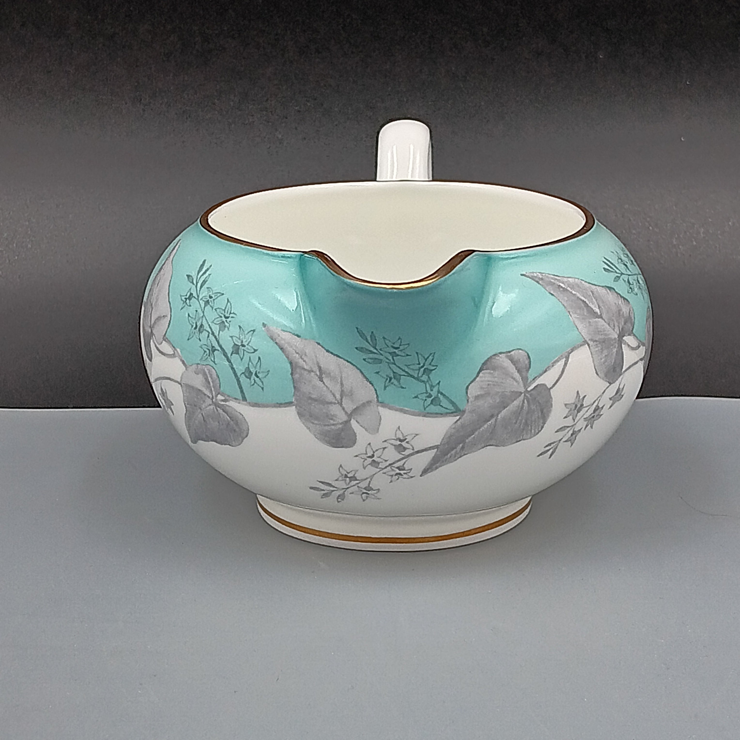 Wedgwood Buxton Turquoise creamer with gold trim, featuring a turquoise band and gray botanical motif on white porcelain