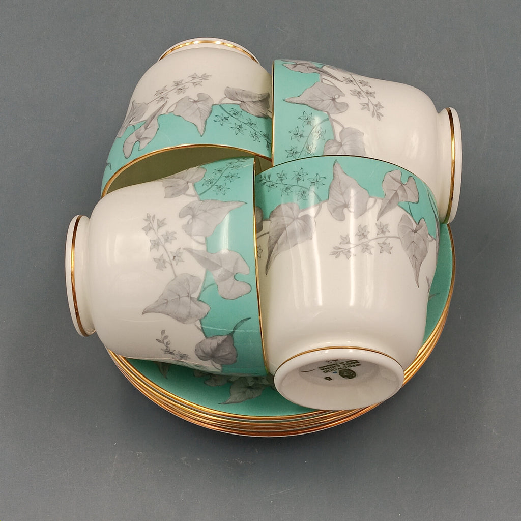 Set of four vintage Wedgwood Buxton Turquoise teacups and saucers with turquoise border, gray floral design, and gold trim