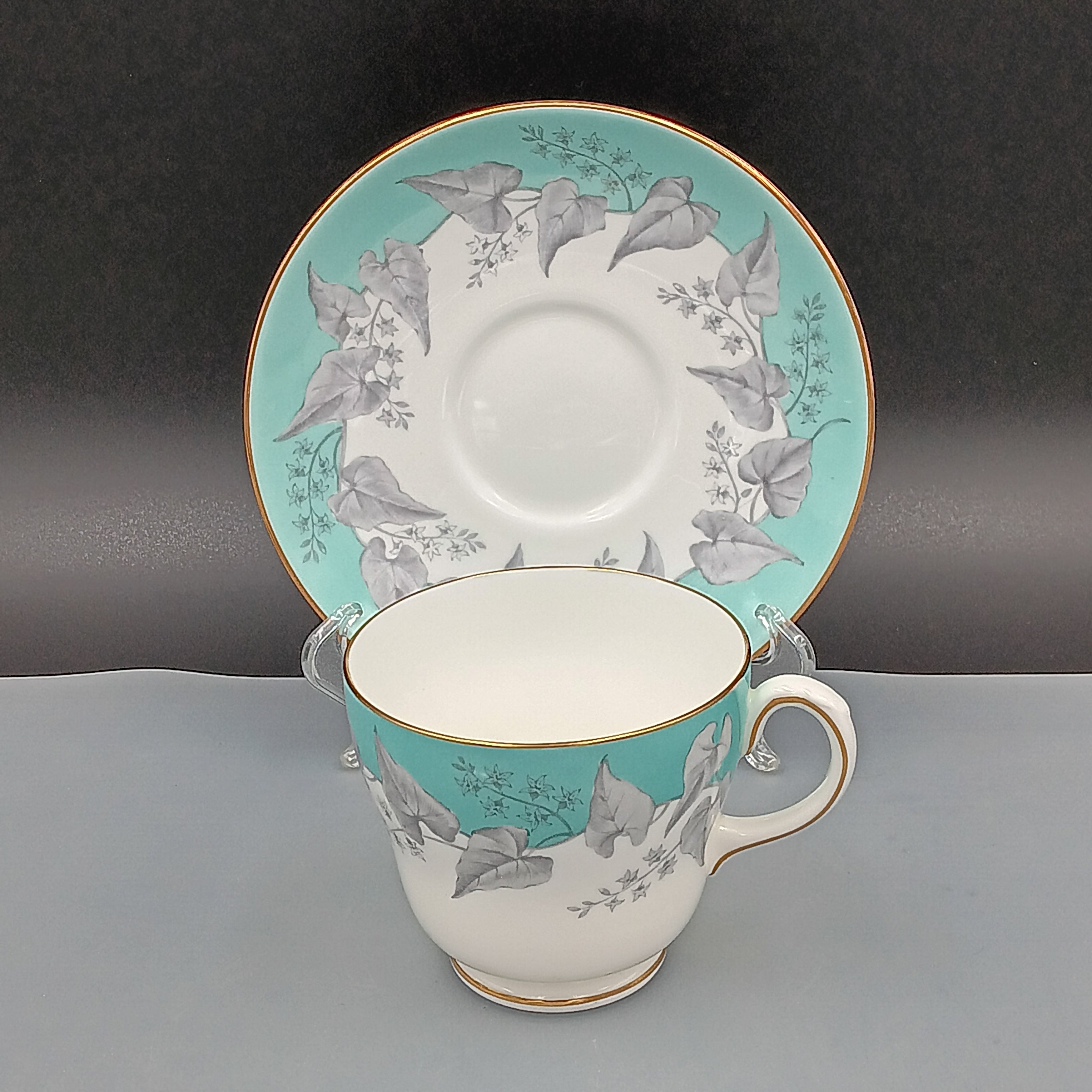 Set of four vintage Wedgwood Buxton Turquoise teacups and saucers with turquoise border, gray floral design, and gold trim