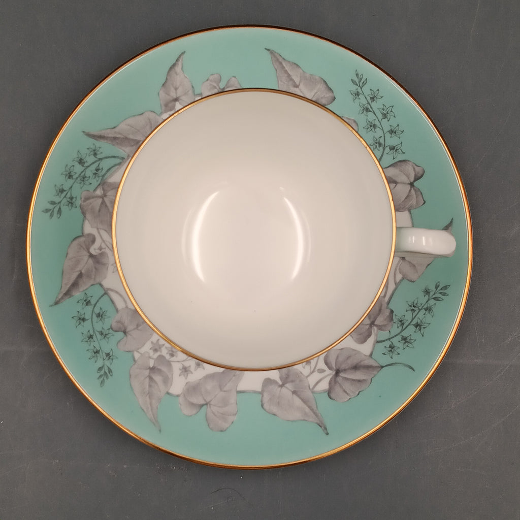 Vintage Wedgwood Buxton Turquoise bone china teacup and saucer set with floral gray leaf pattern, turquoise rim band, and gold trim.