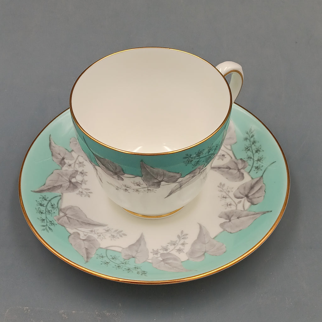 Set of four vintage Wedgwood Buxton Turquoise teacups and saucers with turquoise border, gray floral design, and gold trim
