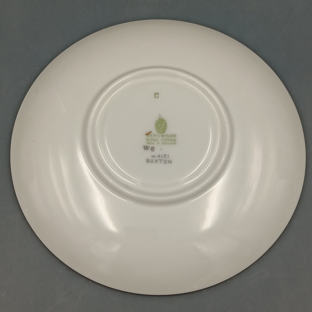 White ceramic plate with a visible brand logo on a gray background