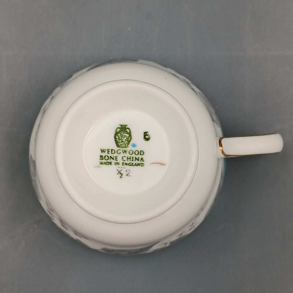 Set of four vintage Wedgwood Buxton Turquoise teacups and saucers with turquoise border, gray floral design, and gold trim