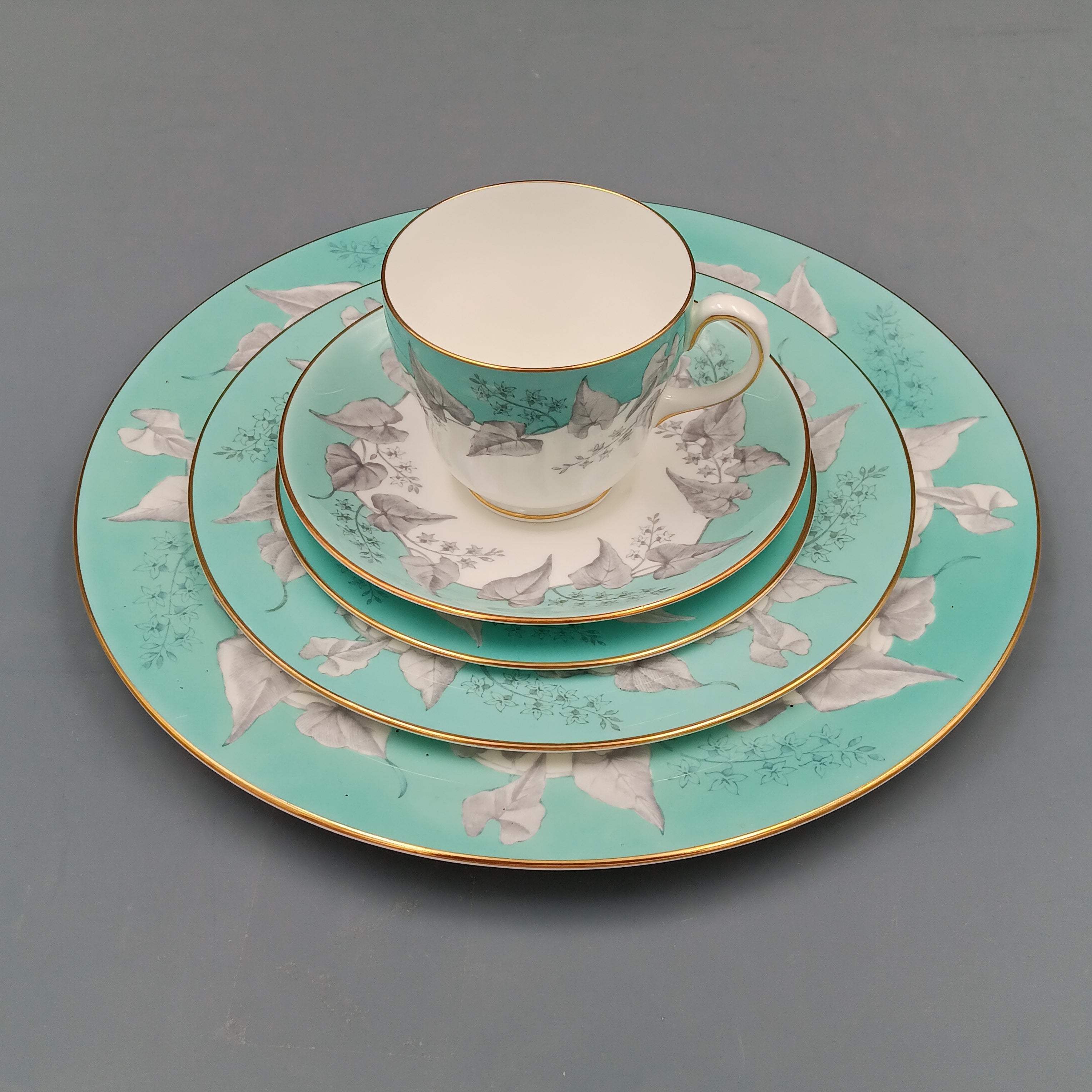 Wedgwood 'Buxton Turquoise' 5-piece vintage dinnerware set featuring a teacup, saucer, and three plates with turquoise floral borders, gold rims, and white porcelain centers.
