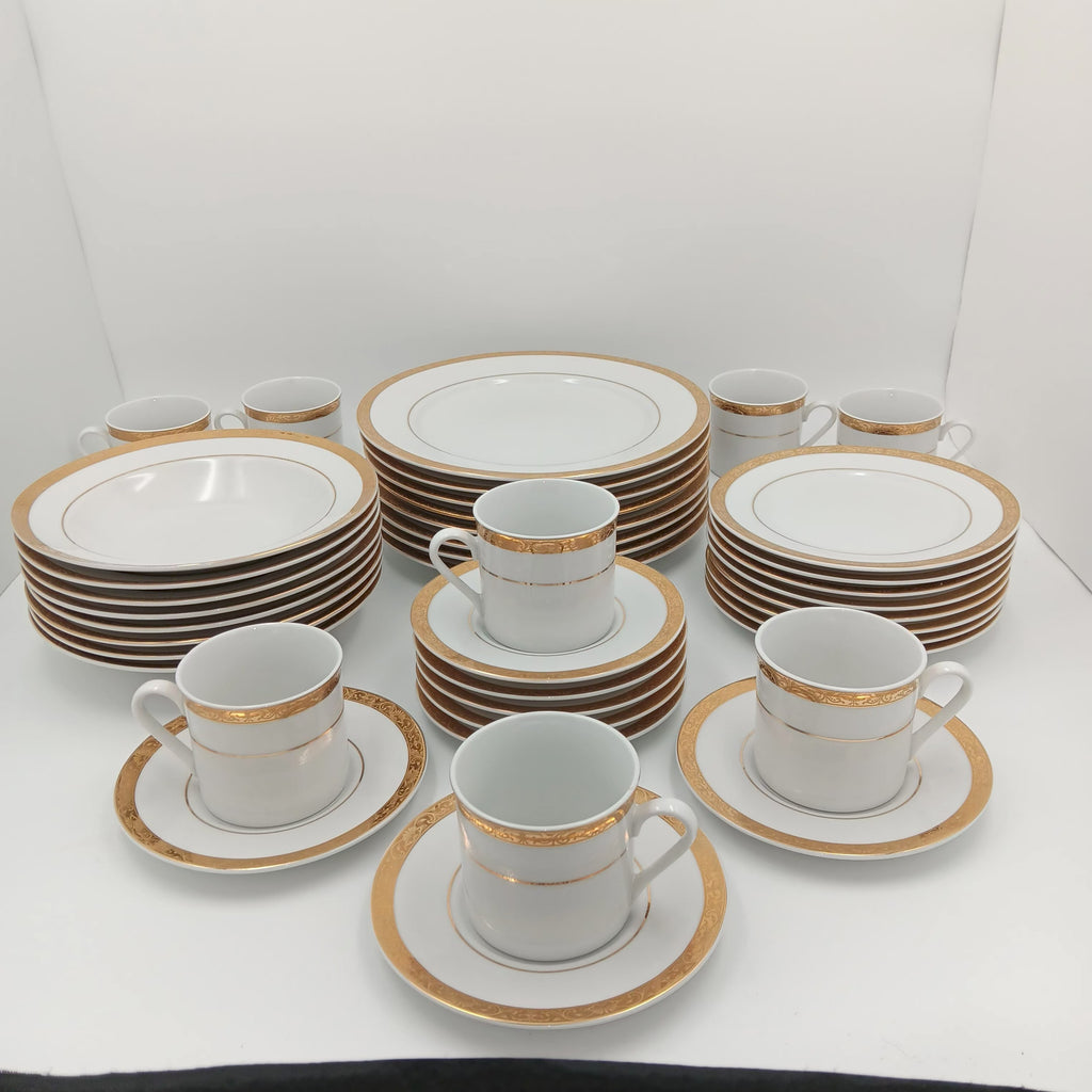 30-piece fine china dinnerware set with white porcelain and gold rim, arranged on white surface